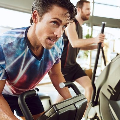 Mann trainiert im Fitnessstudio auf dem Ergometer